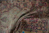 Distressed antique Kerman runner with visible worn pile, cochineal red, navy, and beige florals.