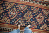 Vintage Persian Kilim runner with Moghan guls, hook and latch patterns in navy, blush, and red.