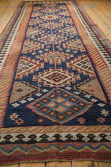 Close-up of navy Persian Kilim guls with interior diamonds and hook motifs in blush, red, and green.