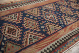 Detail of a vintage Persian Kilim runner showing navy, blush, and chestnut geometric guls.