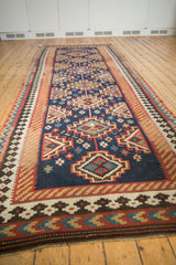 Close-up of vintage Persian Kilim runner's navy blue field and geometric tribal patterns.