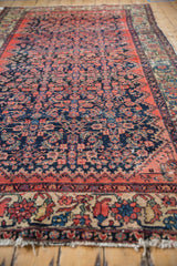 Angled perspective down the vintage Malayer carpet, highlighting visible wear and color abrashes.