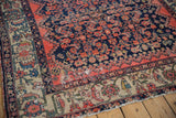 Detail of the worn ivory palmette border and tattered side of a vintage Malayer carpet.