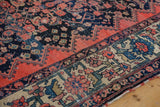 Detailed angle of the vintage Malayer rug showing worn-down pile and a tattered side edge.