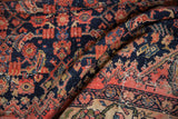 Storied wear on a vintage Malayer rug with foundation showing through the navy blue pile.