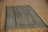 Aged vintage Caucasian rug corner, showing worn cobalt Herati field and Serbend boteh borders.