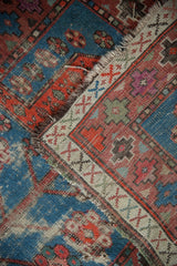 Threadbare indigo blue, red geometric motifs and visible foundation on a Caucasian rug.