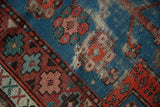 Threadbare blue pile and visible foundation of a worn vintage Caucasian rug.