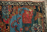 Antique Bijar fragment detail revealing ornate Karabagh design, worn pile, and tattered upper edge.