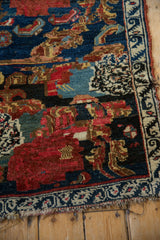 Cherry red floral motif, intricate relief, against a deep navy ground of the antique Bijar.