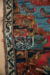 Antique Bijar rug fragment edge with ivory border, dark motifs, red tatter, and intricate multi-color pile.