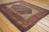 Vintage Kurdish rug's central banded field with geometric patterns in ruby, teal, ivory.
