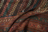 Geometric field and banded borders in ruby red, dusty teal, and ivory on a vintage Kurdish rug.