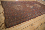 Antique Qashqai carpet medallion with stepped contours, germinating vinery, and aged field patterns.