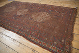 Antique Qashqai carpet side border with madder red, indigo blue tribal motifs, and worn selvage.