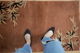 Rust open field and black, ivory eucalyptus leaf motif on an Art Deco rug.