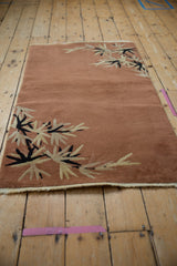 Ivory and navy eucalyptus leaf sprays on a rust vintage Art Deco rug corner with selvage.