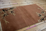 Art Deco rust rug, black and antique ivory eucalyptus leaf pattern, original side cord.