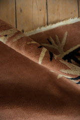 Art Deco rug pile texture showing rust, ivory, and navy eucalyptus leaf spray detail.