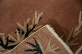 Rug corner shows rust pile, eucalyptus leaf pattern, and hand-knotted foundation.