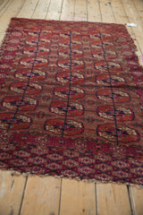 Vintage Turkmen rug's geometric floral gul, lattice, and pomegranate border in madder red and navy.