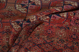 Draped vintage Turkmen rug showing geometric floral gul and lattice patterns in chestnut, madder red, navy.