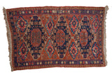 Antique Caucasian Soumac rug, triple geometric medallions, chestnut, navy, and fuchsia palette, early 20th century.