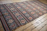 Geometric stripe patterns in navy, terracotta, and ivory on an antique Kuba flatweave Kilim.