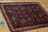 Hamadan rug corner with traditional Herati pattern and banded borders in red and navy.