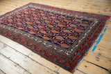 Vintage Hamadan rug corner: navy blue field, staggered red boteh, and geometric borders.