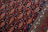 Vintage Hamadan rug detail: navy blue field with alternating tomato red boteh motifs and ivory geometric border.