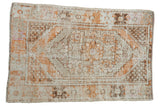 Distressed vintage Oushak rug featuring a stepped medallion in tangerine orange, brown, and worn ivory.