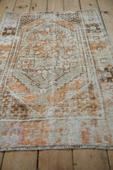 Low angle view across the distressed Oushak rug highlights its even wear and low-knotted pile.