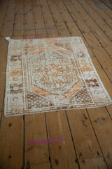 Angled view of a vintage Oushak rug showing its time-softened tangerine and brown medallion pattern.