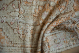 Close-up texture of a distressed Turkish Oushak with low pile worn to the hand-knotted foundation.