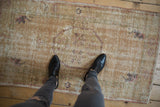 Distressed vintage Oushak rug in sandalwood with faded roundel and floral motifs.
