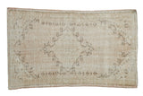 Vintage Distressed Oushak rug with a worn pale rose and cream diamond medallion, 2'6