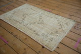 Worn pile texture and pale dusty rose selvage of a vintage distressed Oushak rug.