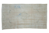 Vintage distressed Oushak rug with a faded central medallion in beige, ivory, and pale denim blue tones.