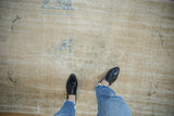 Abrashed field and low, time-softened pile of a distressed vintage Turkish Oushak rug.