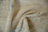 Softly gathered vintage Oushak rug showing its time-softened low pile and sandy, neutral tones.