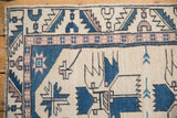 Distressed Oushak rug corner with ivory, denim blue, mauve finned geometric border and fringe.