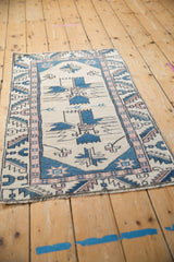 Textural view of distressed Oushak rug with finned geometric florals and serrated border.