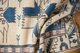 Oushak rug with serrated leaf border and finned patterns in ivory, denim blue, mauve.