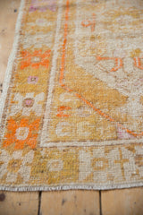 Distressed Oushak rug detail: low pile, saffron yellow, tangerine floral motifs, exposed foundation.