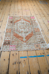 Distressed Oushak rug: lozenge medallion with pale rust, sand, and hot pink floral motifs.