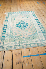 Distressed Oushak rug corner, muted teal starburst, potted vase, and pinwheel floral patterns.