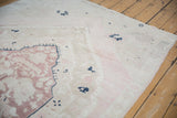Distressed Oushak rug pile, soft dusty mauve and ivory hues, showing striations and wear.