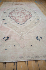 Distressed Oushak carpet pile, featuring soft mauve, beige, and faint navy striations with even wear.