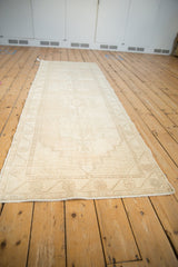 Distressed Oushak runner corner detail, showcasing stepped spandrels, worn ivory and sand texture.